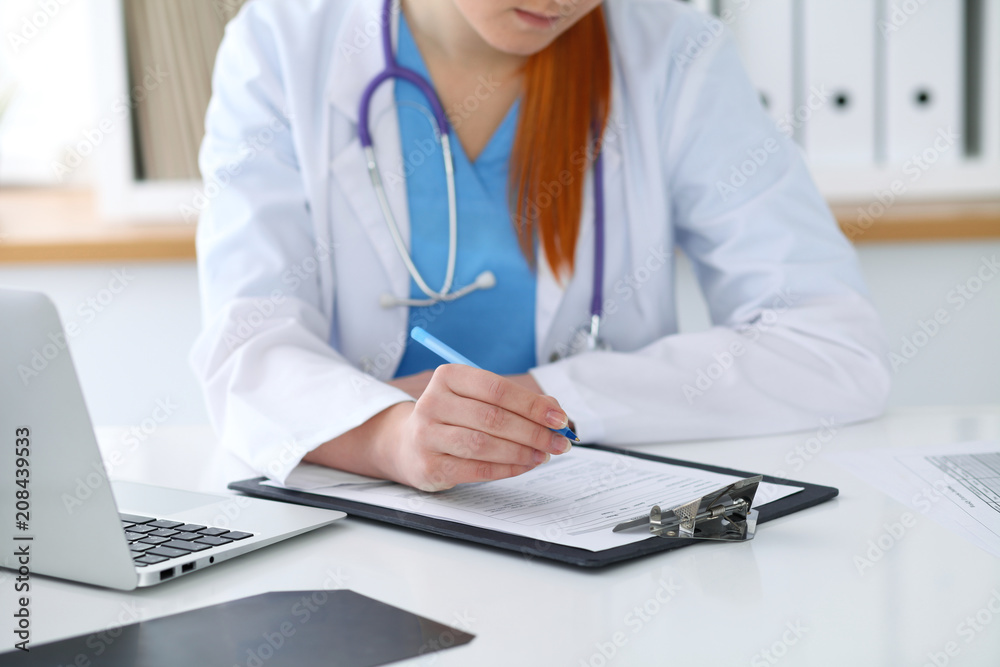 Unknown female doctor filling up medical form on clipboard closeup. Healthcare, insurance and medicine concept Unknown female doctor filling up medical form on clipboard closeup. Healthcare, insurance and medicine concept