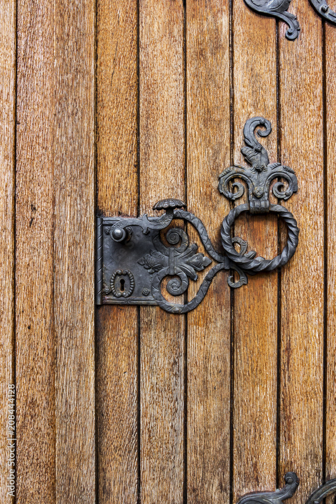 Detail of a side wooden door with iron decoration at St. Stephen's Church, Reuland, Burg-Reuland, Belgium