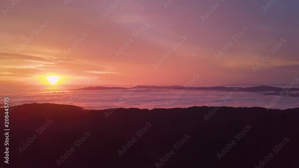 Sun sets over mist covering valley leading to ocean, beautiful heaven light time lapse. Sun sets over mist covering valley leading to ocean, beautiful heaven light time lapse.