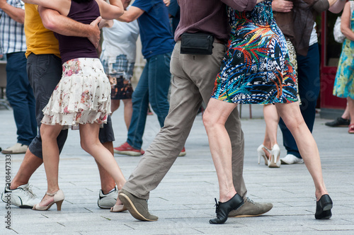 closeup of legs of couple of tango dancers in the street