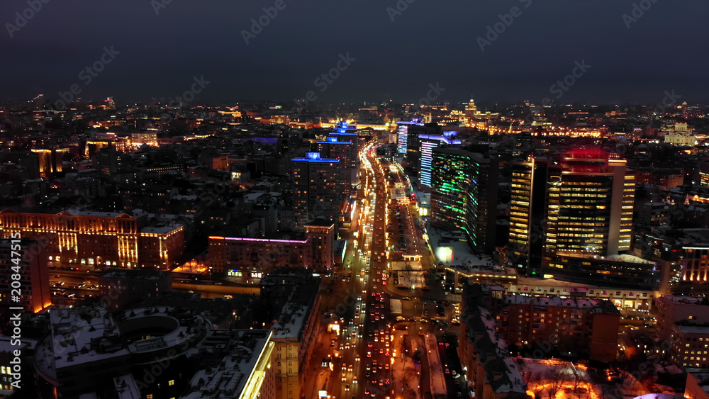 Bright lights of night Moscow from bird's eye view. Intensive traffic at New Arbat street in the heart of the city. Illuminated multistory houses on the sides of the wide avenue.