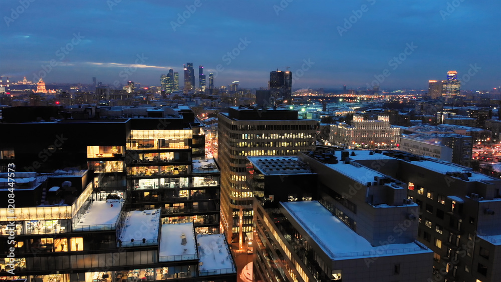 Obraz premium Moscow White square modern business center. Winter evening smooth aerial shot. Open-space offices through the illuminated windows.