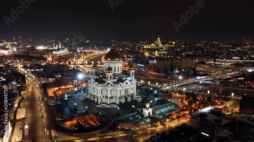 Flying around the Cathedral of Christ the Savior in Moscow. Bright lights of night city life. River Moskva and city panorama at night.