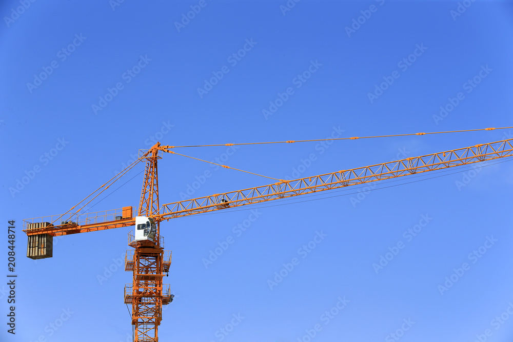 The crane is working at the construction site The crane is working at the construction site