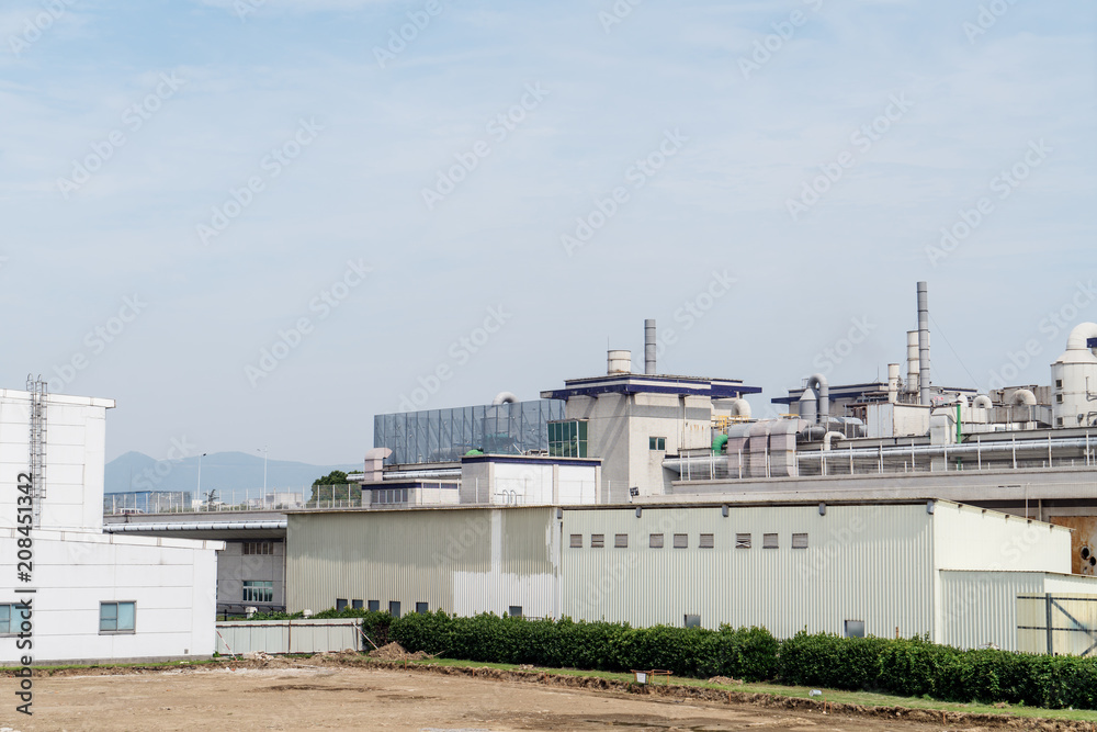 Factory building in the suburbs, industrial plant background Factory building in the suburbs, industrial plant background