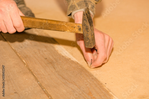 A man is hammering small nails.