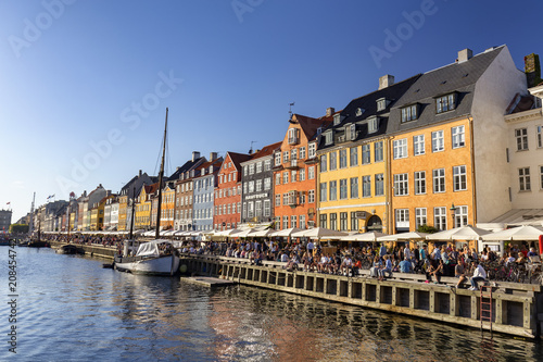 COPENHAGEN  DENMARK - AUGUST 26  Unidentified pedestrians walk past beautiful buildings in Copenhagen  Denmark on August 26  2016.