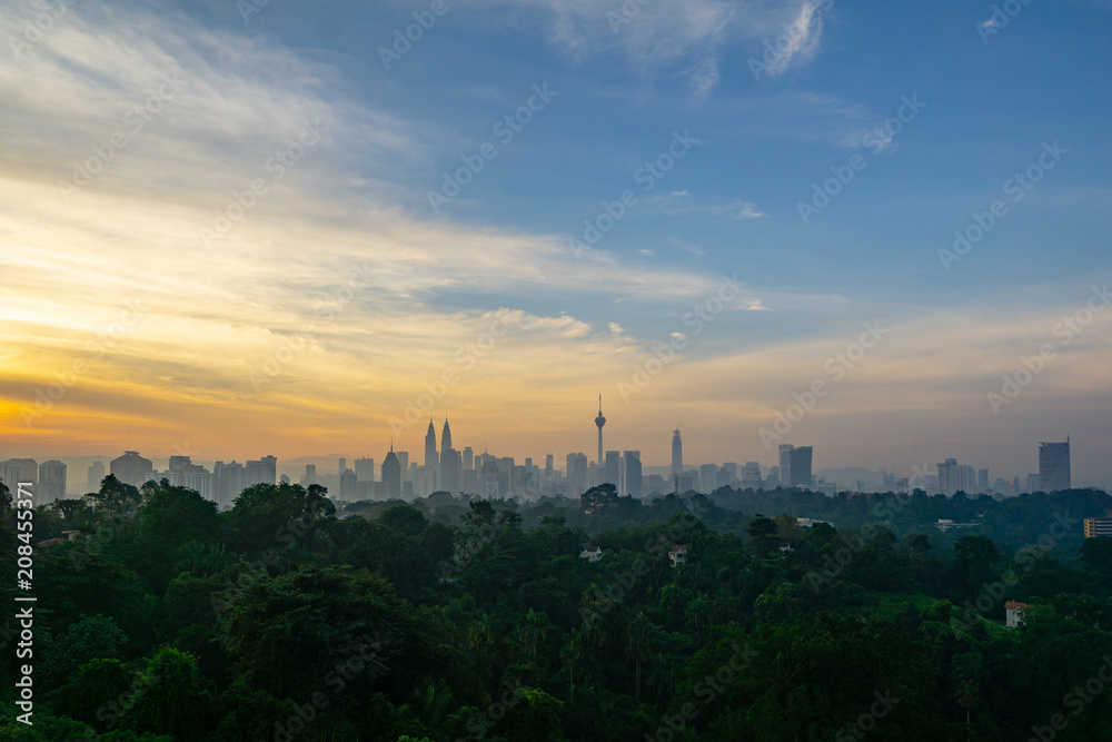 Cloudy sunrise over KL Tower and surrounded buildings in downtown Kuala Lumpur, Malaysia.	