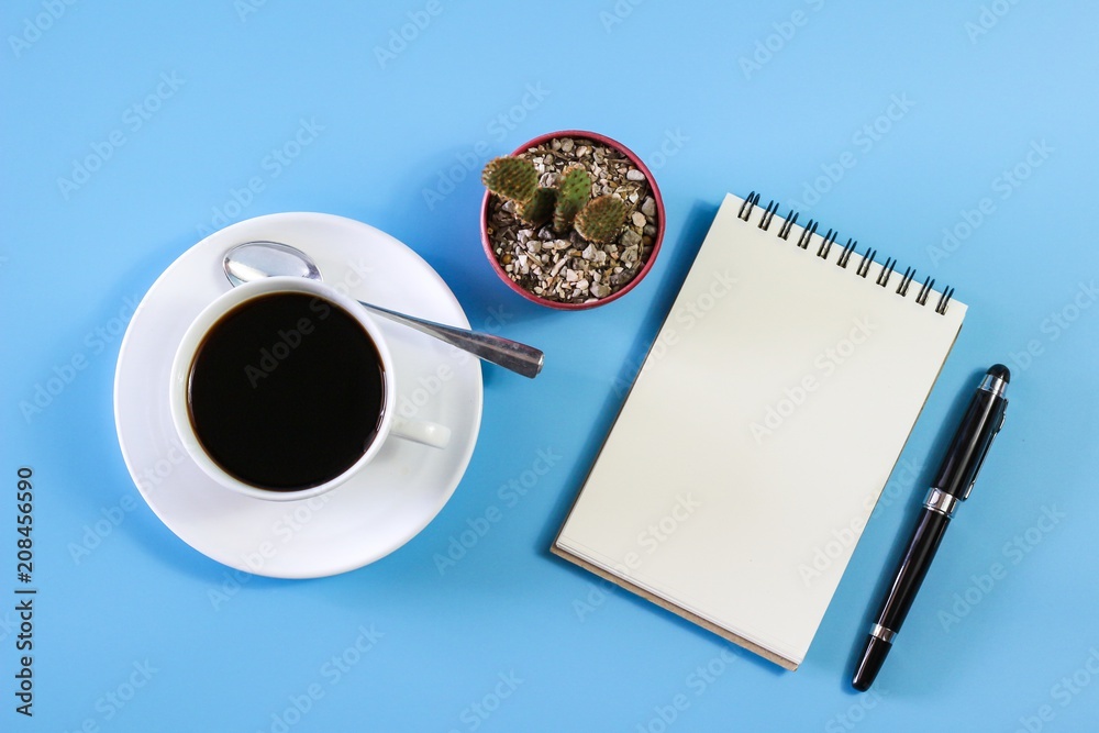 Flat lay photo with notebook , coffee cup Pen and Cactus on blue background Flat lay photo with notebook , coffee cup Pen and Cactus on blue background