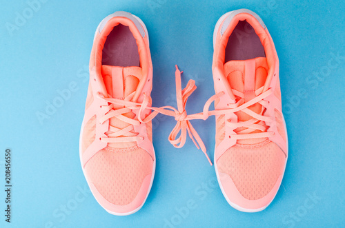 Flat lay pink sneakers on bright background. Casual sport concept