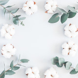 Flowers composition. Frame made of cotton flowers and eucalyptus branches on pastel blue background. Flat lay, top view, square, copy space