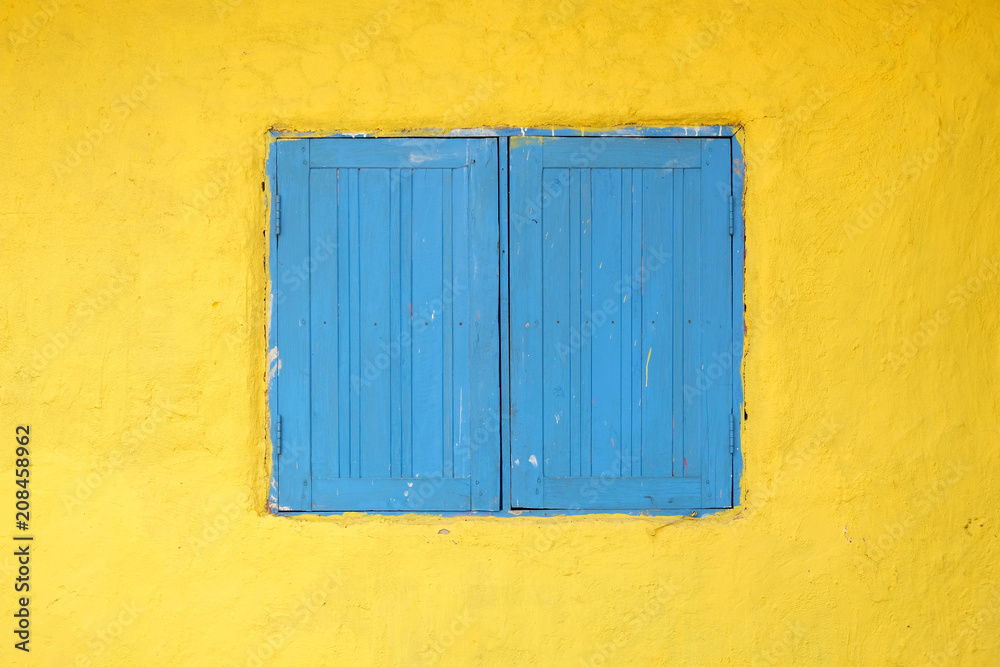 Blue wooden window on the yellow background