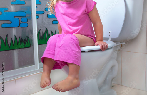 A child is sitting on the toilet