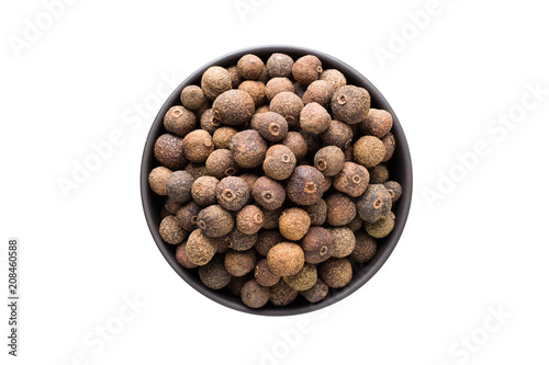 Tela allspice pepper in clay bowl isolated on white background