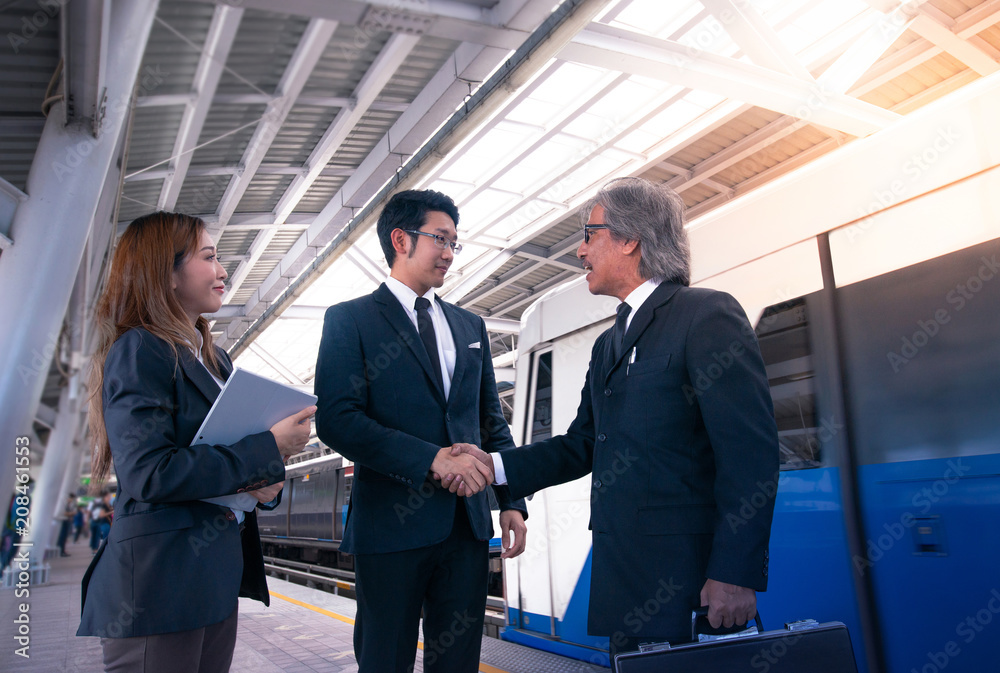 Businessmen shaking hands on platforms at the public railway station in Thailand Businessmen shaking hands on platforms at the public railway station in Thailand