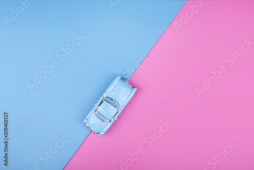 Travel blue car model on pink blue background. Top view