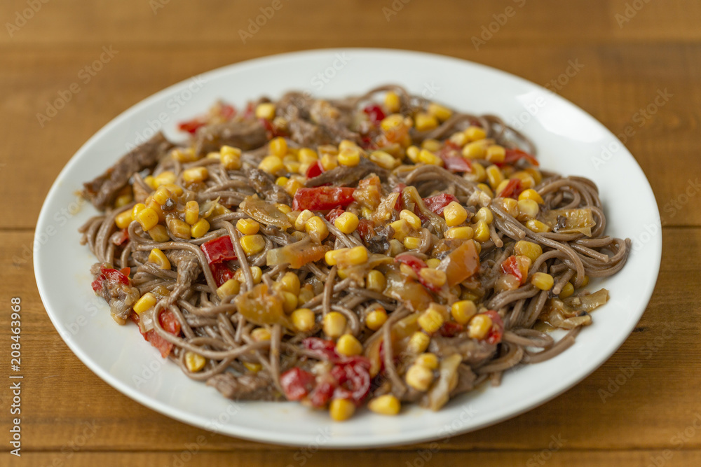 Soba noodles with beef, corn, onions and sweet peppers. Top view Soba noodles with beef, corn, onions and sweet peppers. Top view