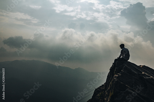 Male sitting edge of a mountain in uttarakhand india