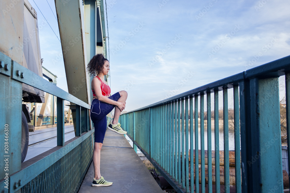 Fit young long curly dark hair girl exercise and stretch on the bridge Fit young long curly dark hair girl exercise and stretch on the bridge