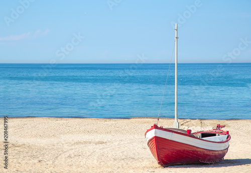 red fishing boat on the beach with blue ocean background in Denmark
