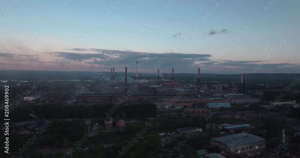 Top view, AERIAL: highway and industrial plant. Air pollution from industrial plants. Pipes throwing smoke in the sky at sunset Top view, AERIAL: highway and industrial plant. Air pollution from industrial plants. Pipes throwing smoke in the sky at sunset