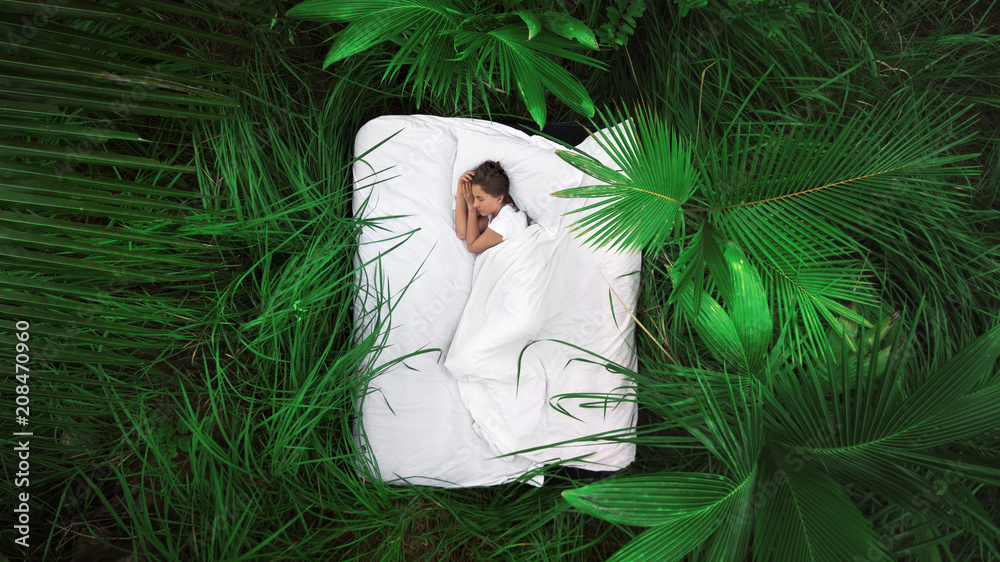 A hidden place. Sleeping woman in deep jungle forest lies on airbed,View from above - obrazy, fototapety, plakaty 