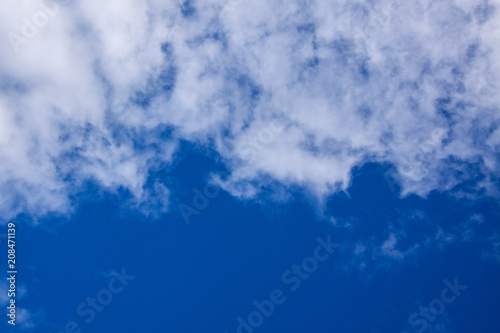 White clouds occupy half of the blue sky