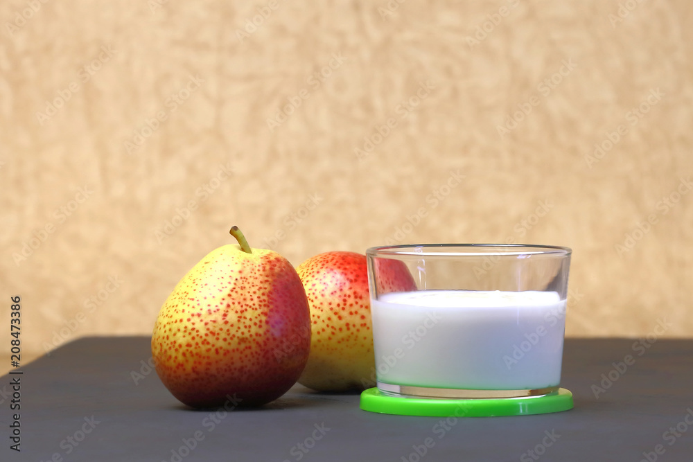 Dietary food. Dessert of milk. Milk product on a beige background. Creamy yogurt in a glass jar with fresh pears for a healthy diet. Dietary food. Dessert of milk. Milk product on a beige background. Creamy yogurt in a glass jar with fresh pears for a healthy diet.