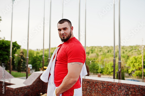 Young brutal bearded muscular man wear on white sport suit with red shirt.
