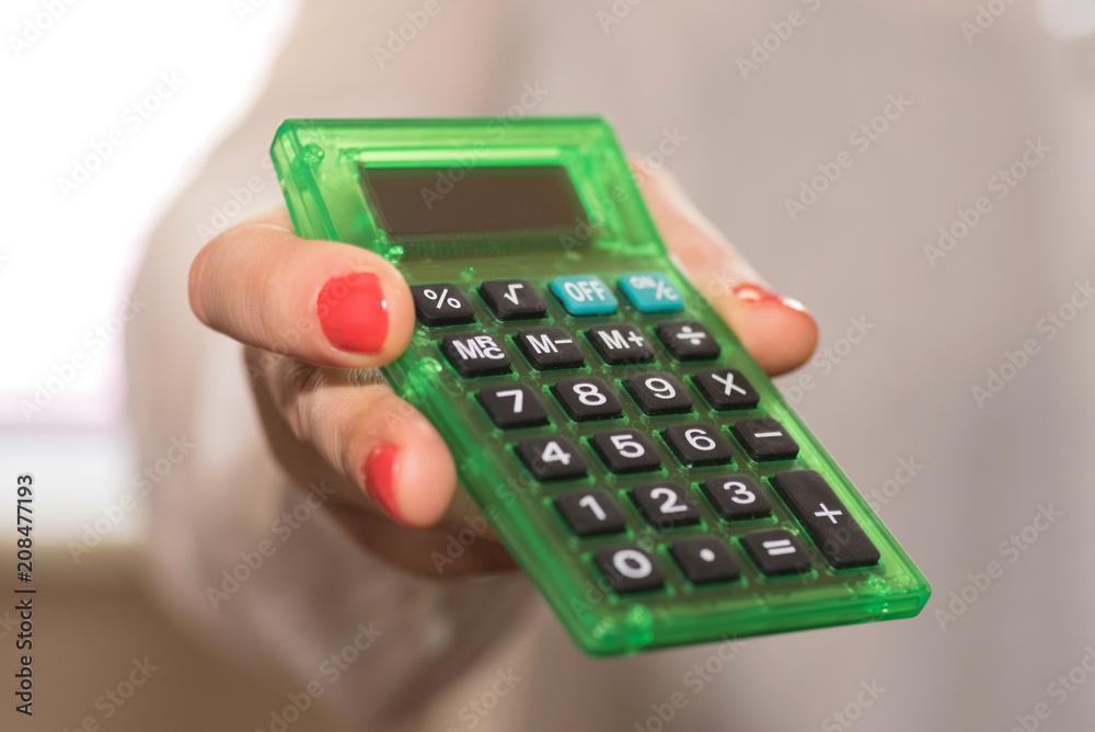 Eine Frau hält einen Taschenrechner in der Hand Eine Frau hält einen Taschenrechner in der Hand