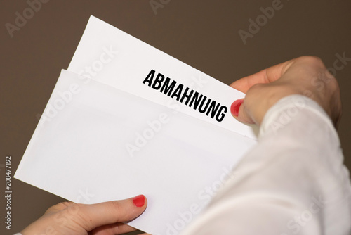 Eine Frau hält eine Abmahnung in den Händen