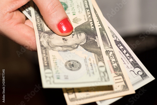 Eine Frau hält Dollar Geldscheine in der Hand