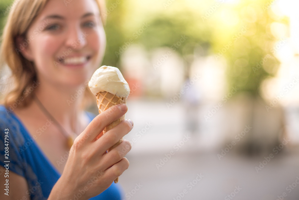 Glückliches junges Mädchen isst ein Eis, Sommer