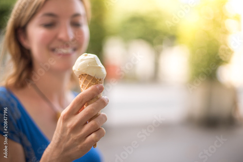 Glückliches junges Mädchen isst ein Eis, Sommer