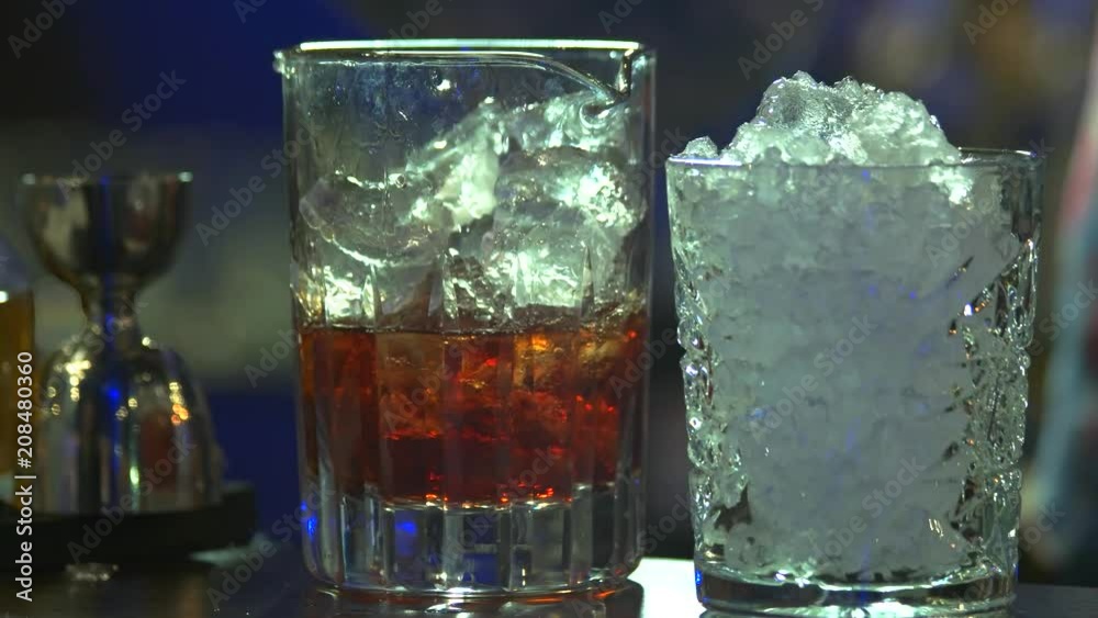 Cooking brandy with ice. Adding ice cubes to the brandy coctail. Cooking brandy with ice. Adding ice cubes to the brandy coctail.
