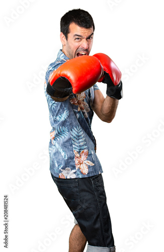 Handsome man with flower shirt with boxing gloves on isolated white background