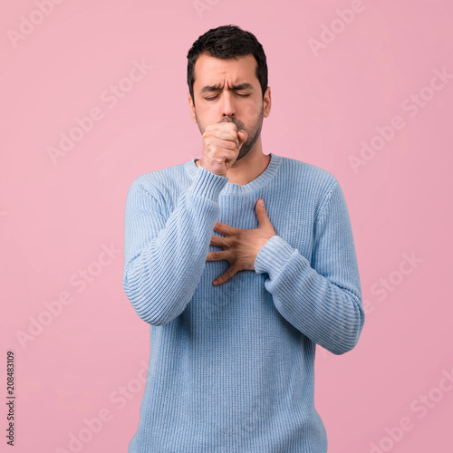 Fototapeta Handsome man is suffering with cough and feeling bad on pink background
