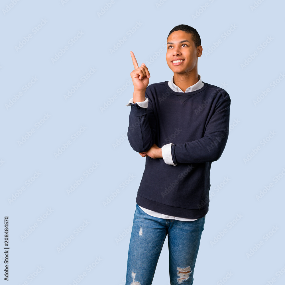 Young african american man pointing with the index finger a great idea on isolated blue background Young african american man pointing with the index finger a great idea on isolated blue background