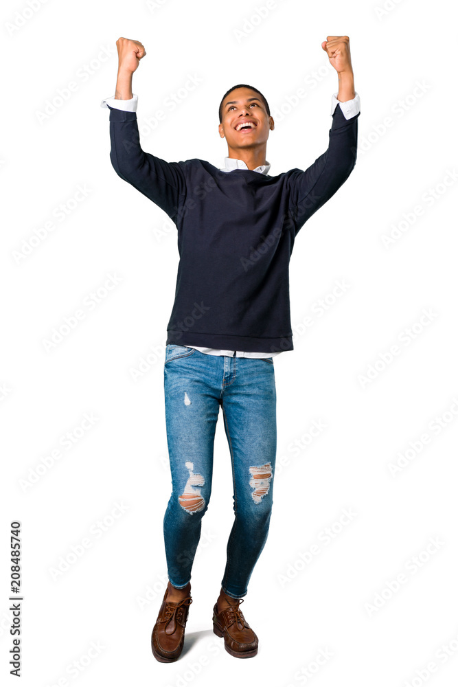 Young african american man celebrating a victory and happy for having won a prize on isolated white background Young african american man celebrating a victory and happy for having won a prize on isolated white background