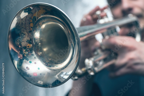 The trumpeter is playing on a silver trumpet. Trumpet player