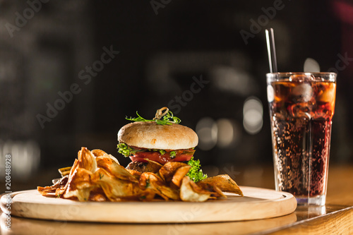 A delicious fresh hamburger with Coca Cola on a bar counter