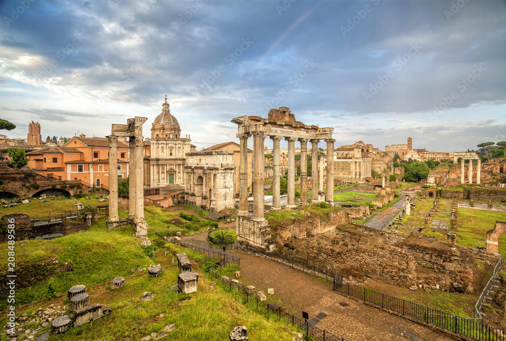 View of the temple of Saturn in Roman forum, Italy. Ruins of Septimius Severus Arch and Saturn Temple. Rome architecture and landmark.