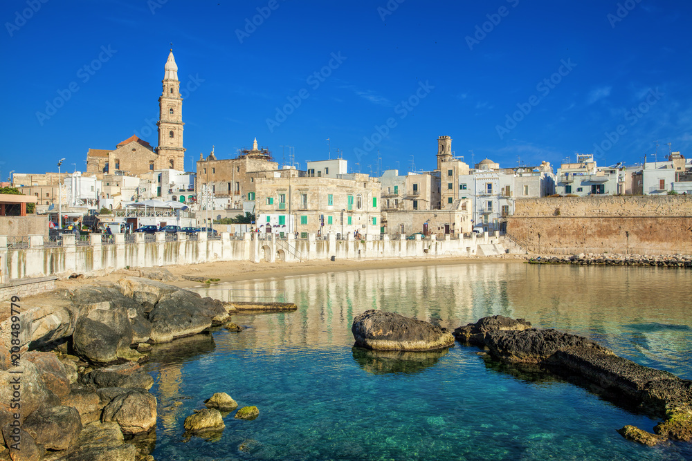 Scenic sight in Monopoli, province of Bari, region of Apulia, southern Italy. City scape harbor walled city Cathedral.