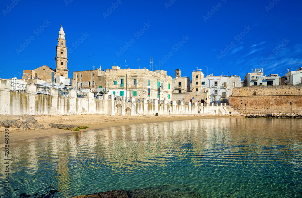 Scenic sight in Monopoli, province of Bari, region of Apulia, southern Italy. City scape harbor walled city Cathedral.