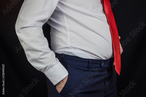 A man in a white shirt and tie with a bloated stomach © HENADZY