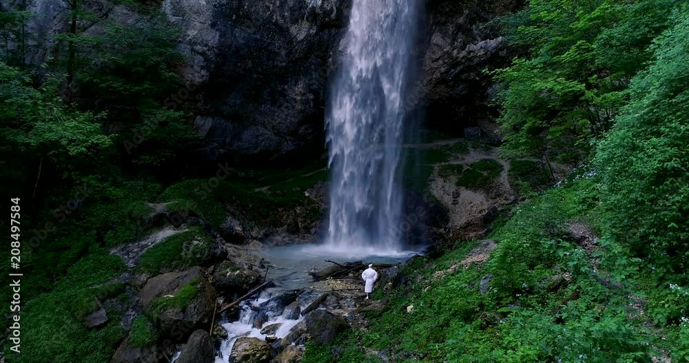 European man with beard is doing waterfall-meditation while standing under big waterfall in austria, wildensteiner waterfall European man with beard is doing waterfall-meditation while standing under big waterfall in austria, wildensteiner waterfall
