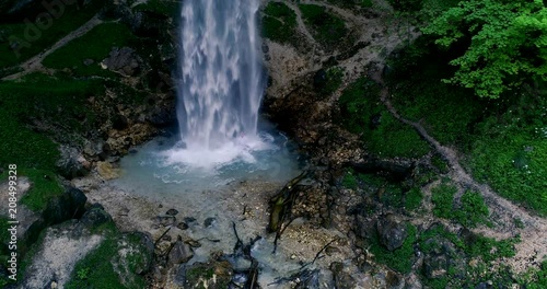 European man with beard is doing waterfall-meditation while standing under big waterfall in austria, wildensteiner waterfall photo