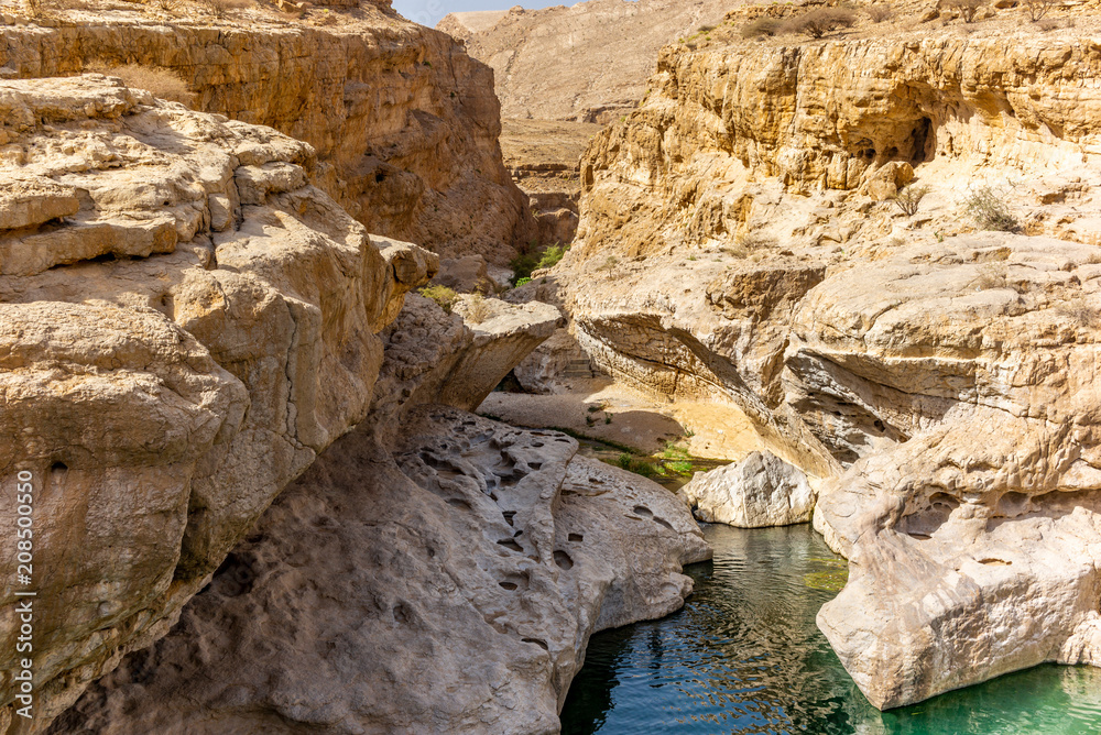 A stream of water in the rocky desert of Oman flowing in a canyon to the oasis of Wadi Bani Khalid - 7