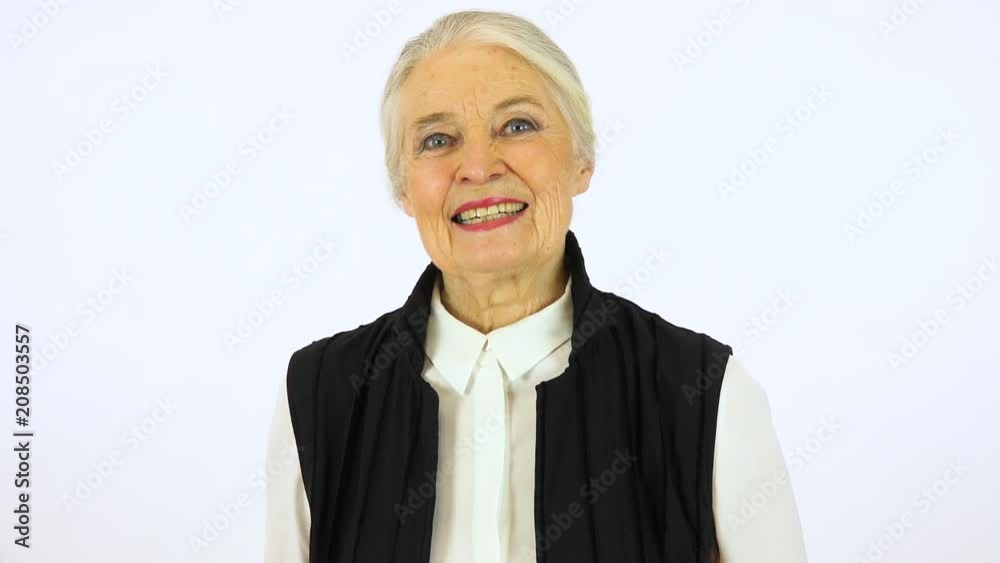 An elderly woman smiles at the camera - white screen studio An elderly woman smiles at the camera - white screen studio