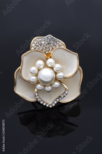 gold brooch flower with a pearls and diamonds isolated on black